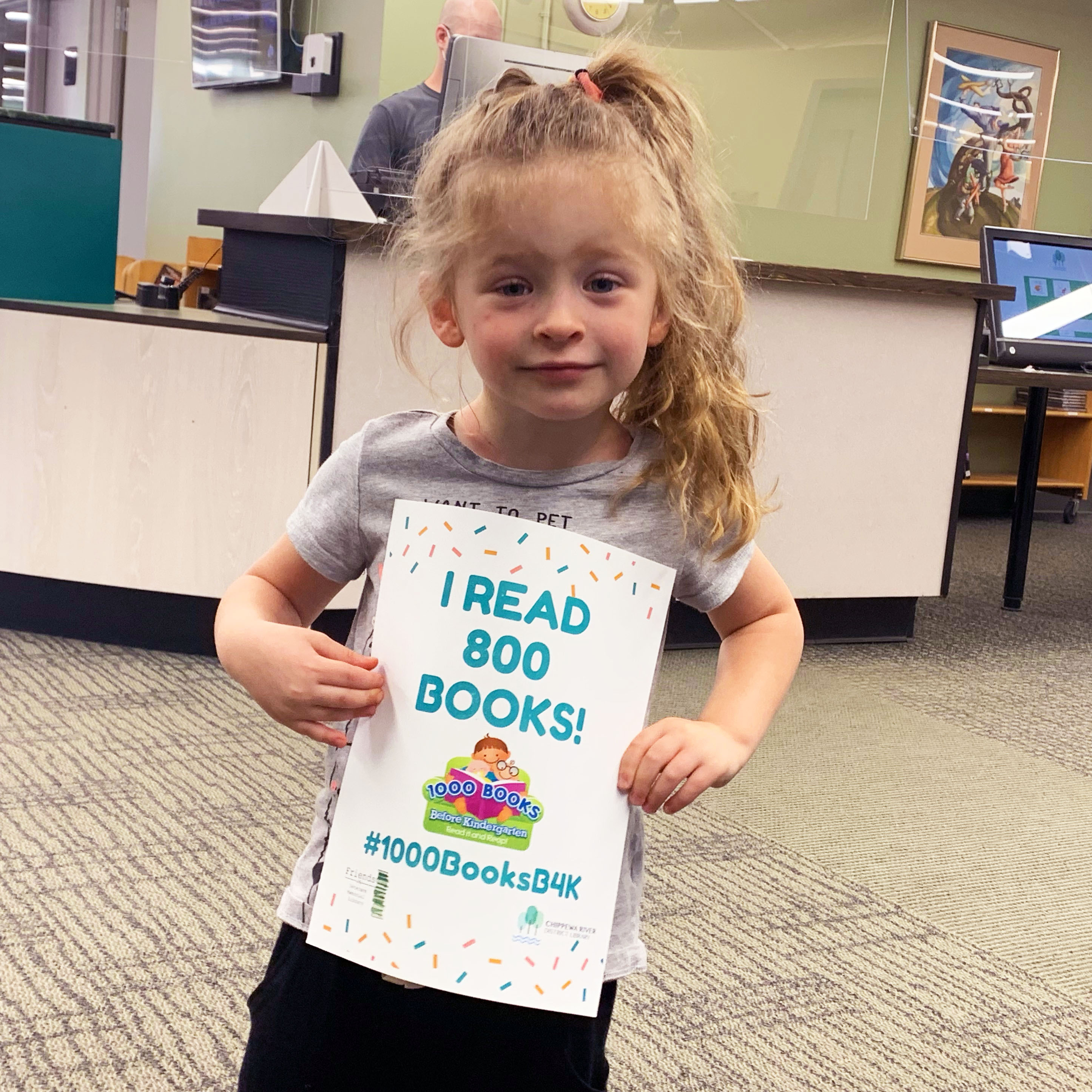 Young girl holding "I read 800 books sign."