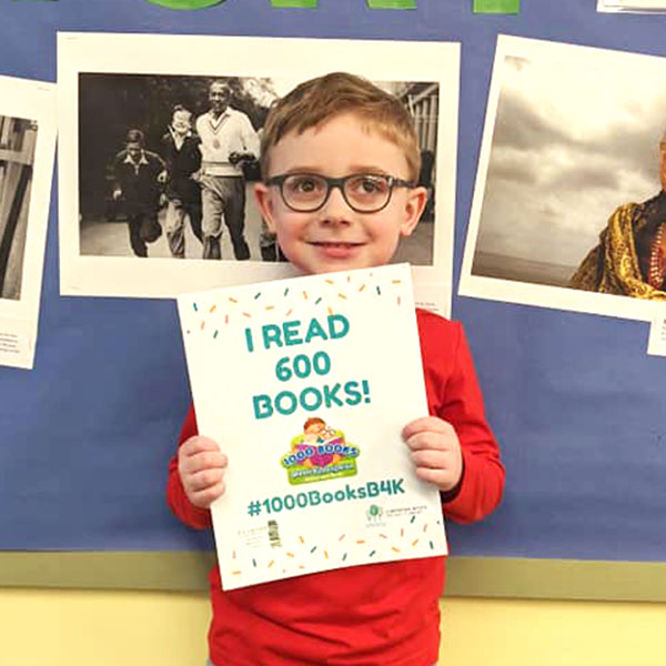 Young boy holding "I read 600 books sign."