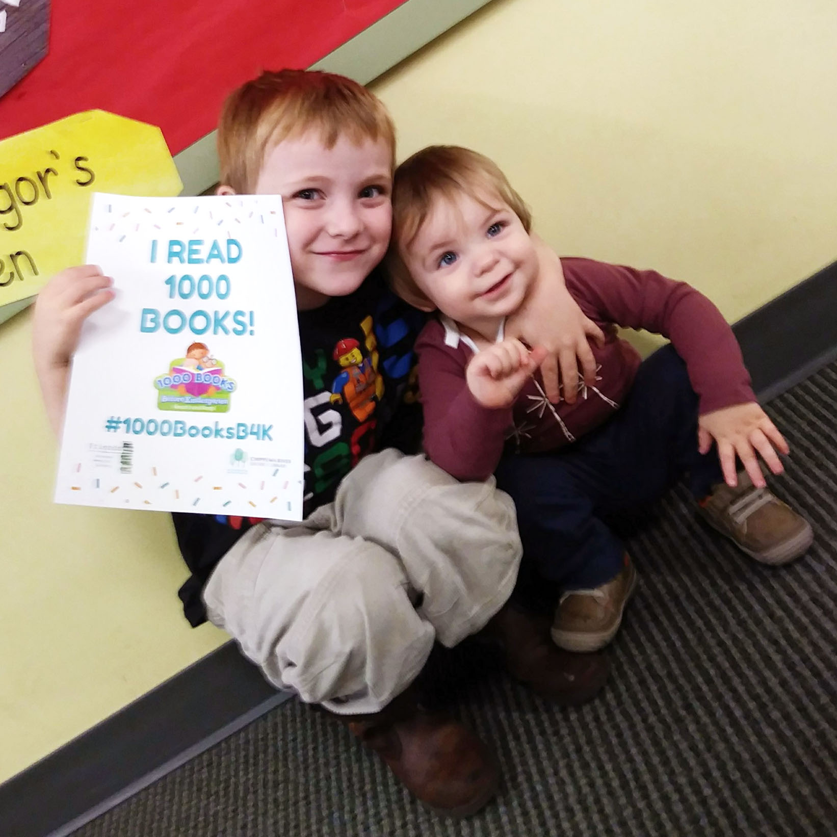 Two young boys holding "I read 1000 books sign."