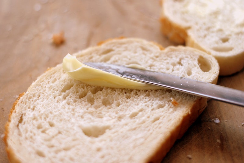 Image of knife spreading butter on bread