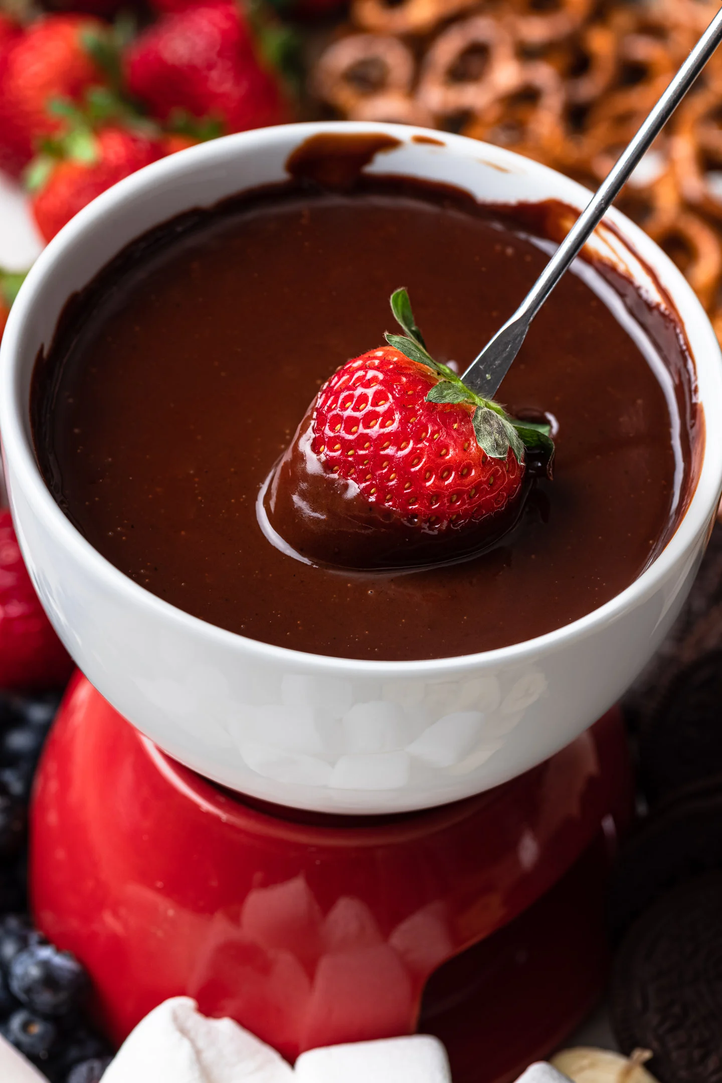 Image of fondue pot filled with chocolate and a strawberry being dipped