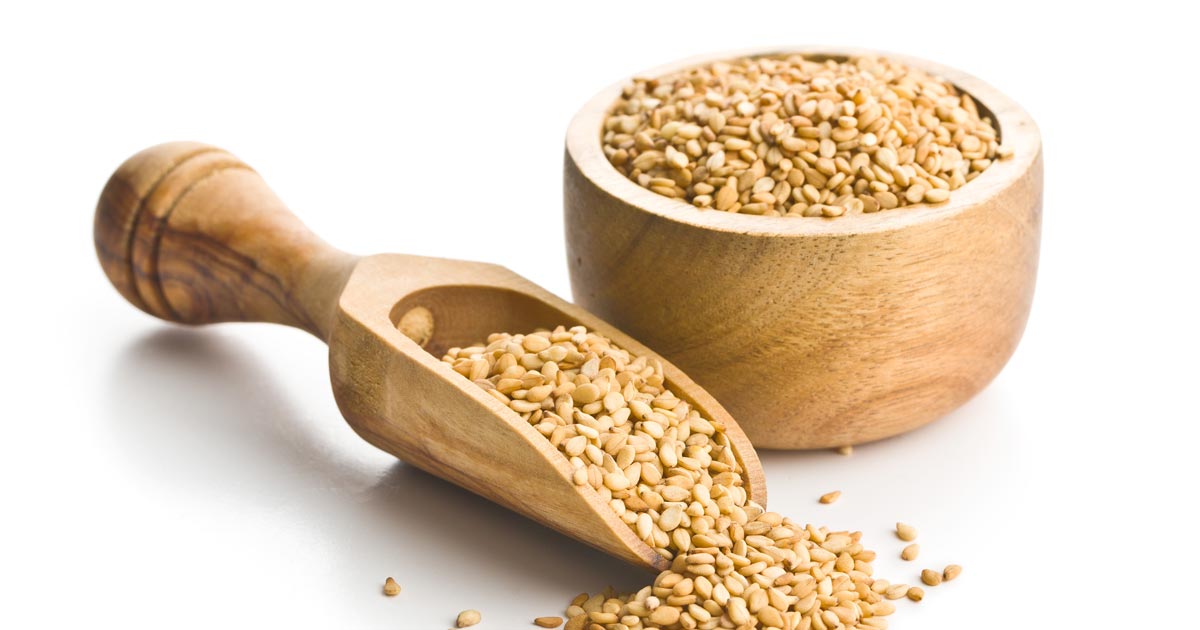 Image of a wooden bowl and scoop filled with sesame seeds