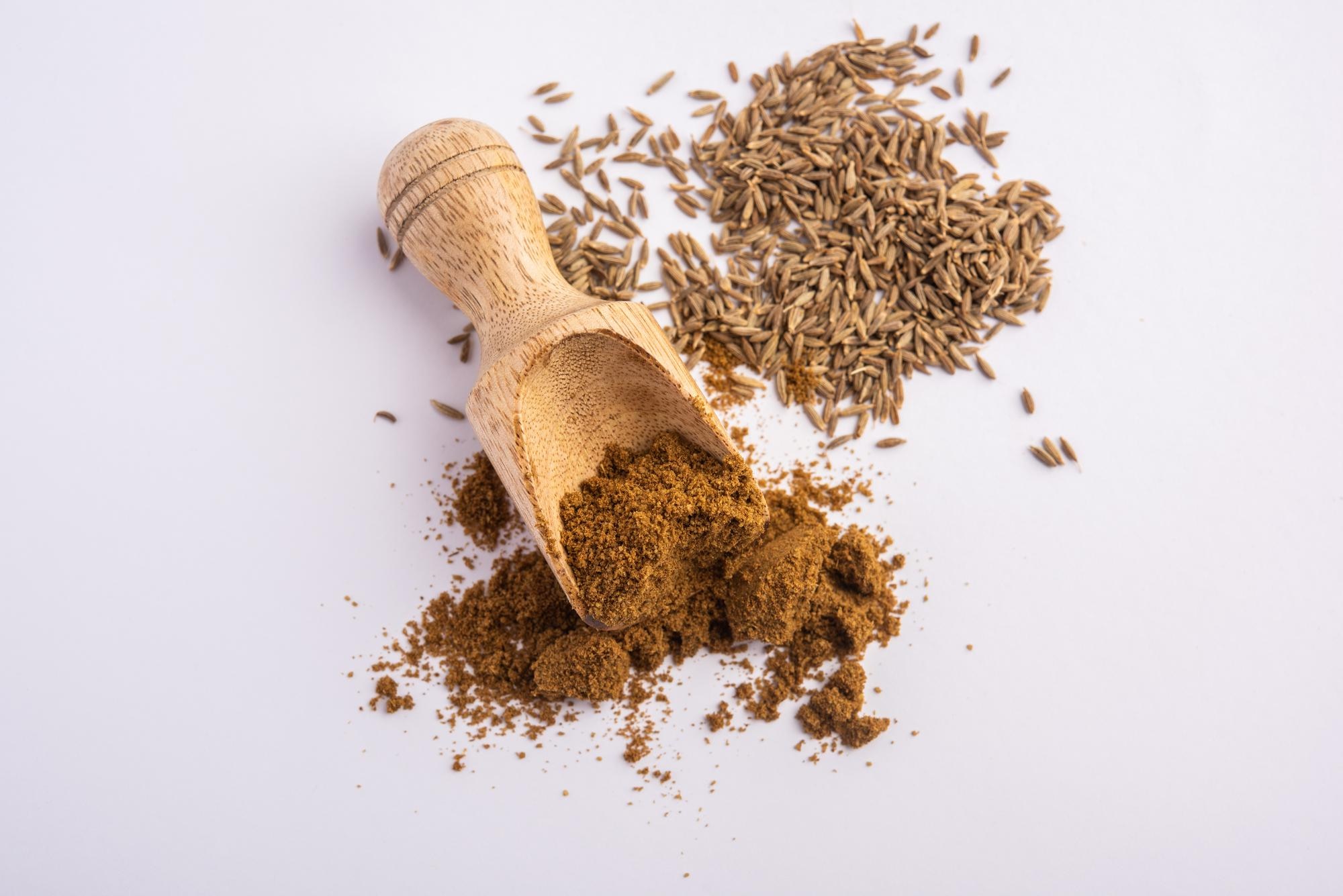 Image of a wooden scoop filled with cumin spice