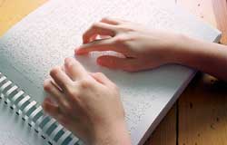 Image of hands reading a braille book.