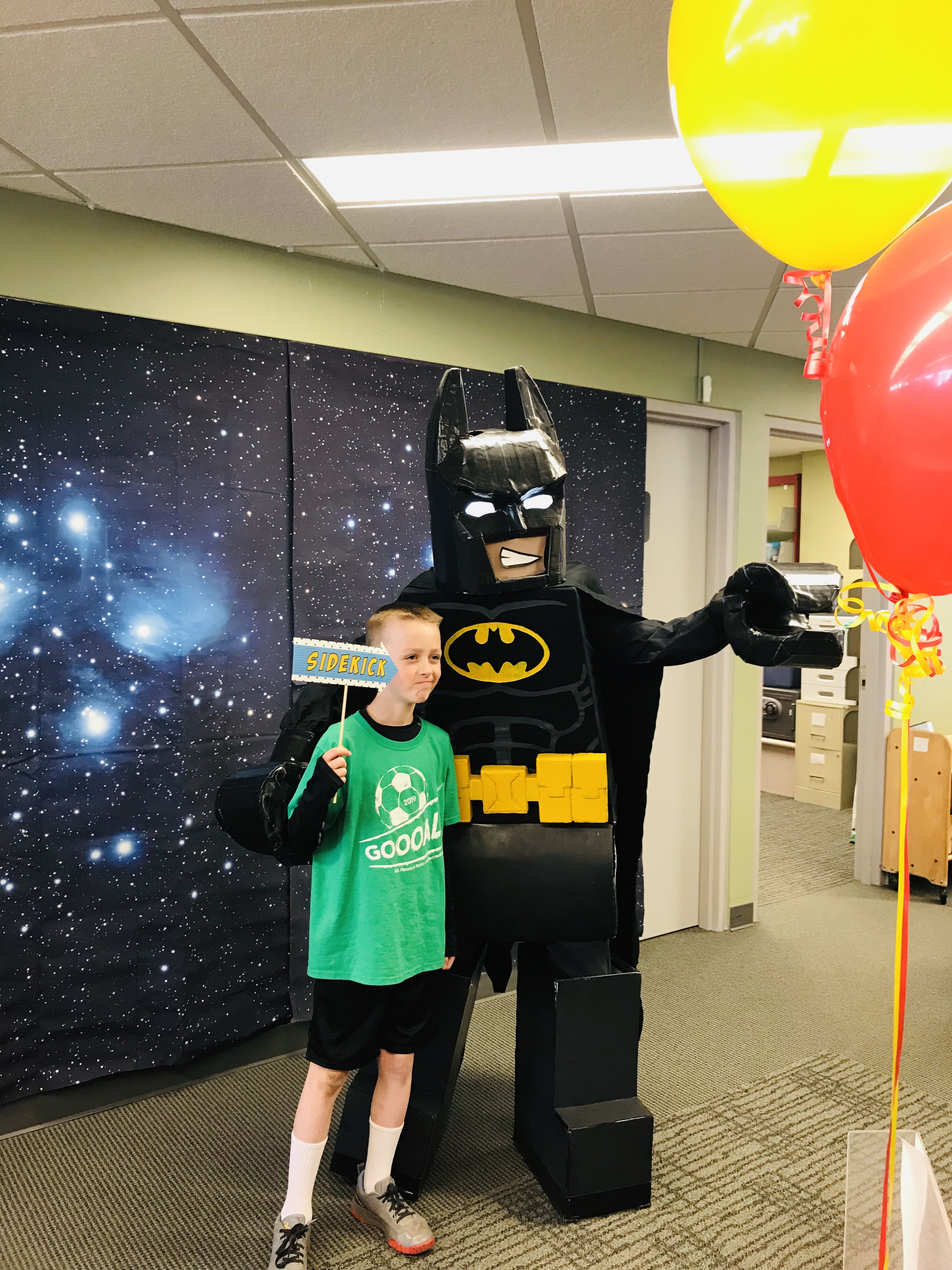 child posing next to LEGO Batman costume character