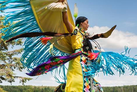 Ojibwe woman dancingin native dress.